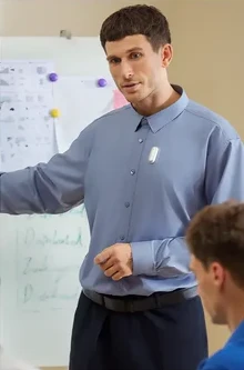 A teacher is wearing a Plaud NotePin whilst working